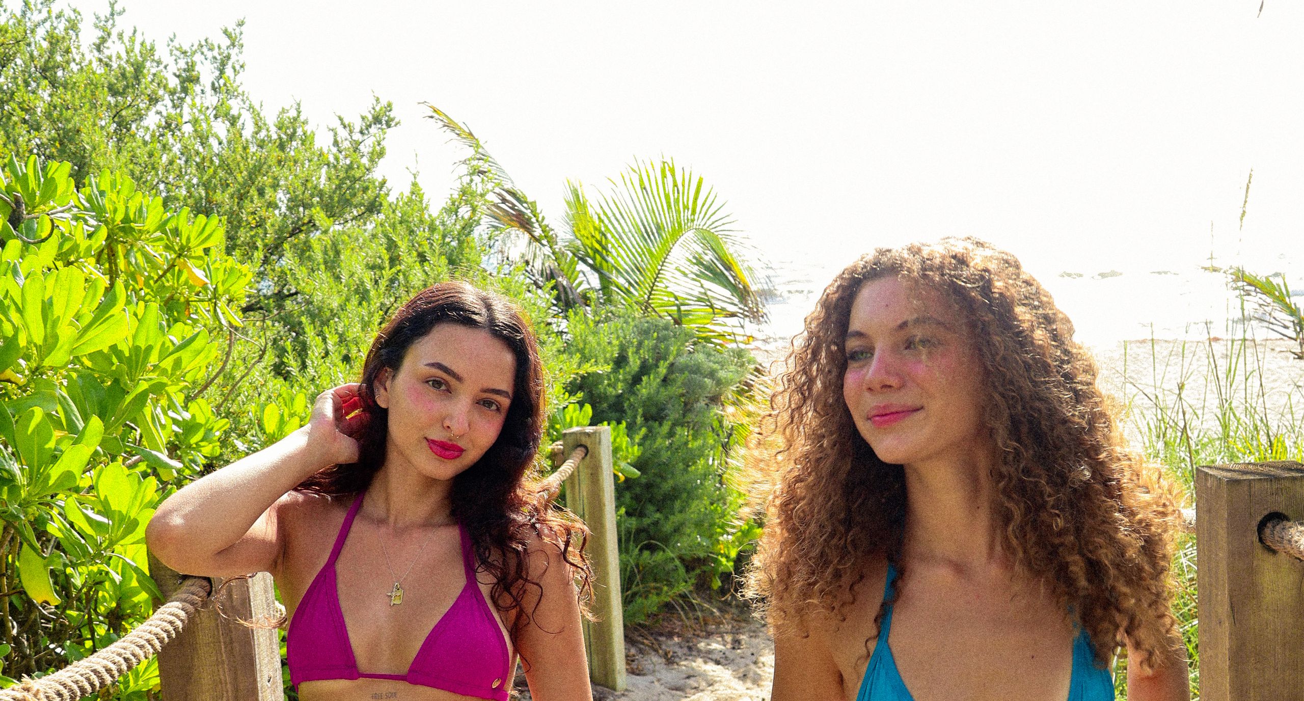 Two girls in AquaBerry bikinis on a beach path